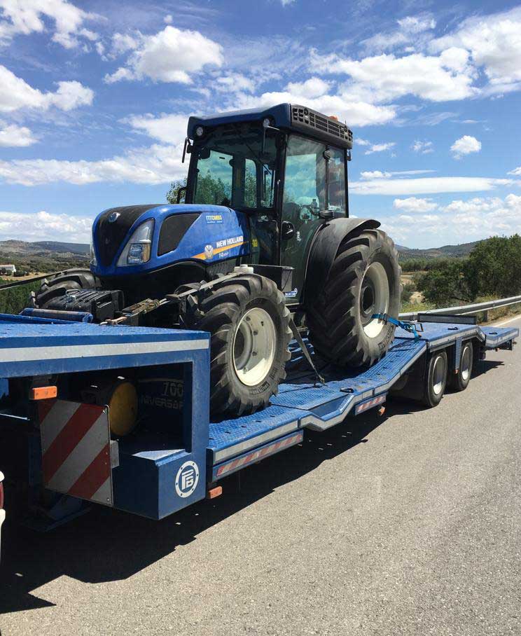 camión transportando tractor